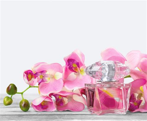 Premium Photo | Perfume bottle and flowers on background.