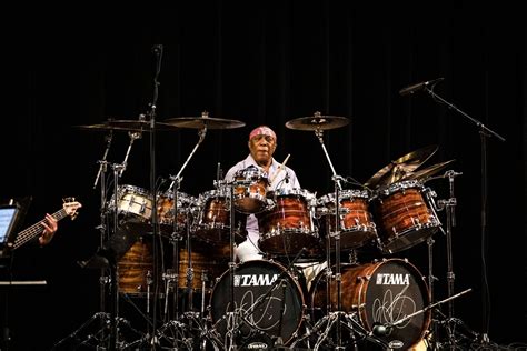 two men are playing drums on stage