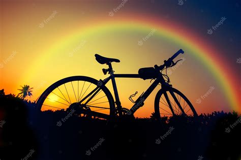 Premium Photo | Silhouette bicycle on sunset and rainbow