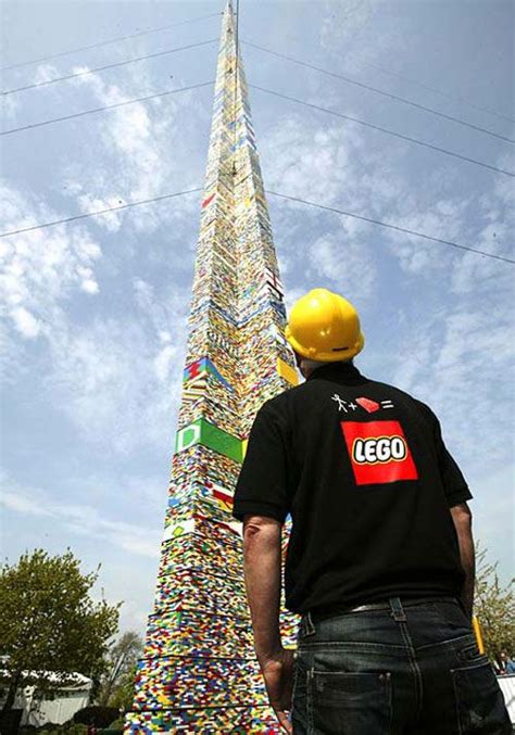 a man standing in front of a tall building made out of legos