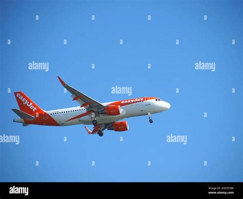 Orange easyJet airplane flying with blue sky Stock Photo - Alamy