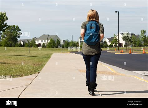 Female high school student walking along pavement Stock Photo - Alamy