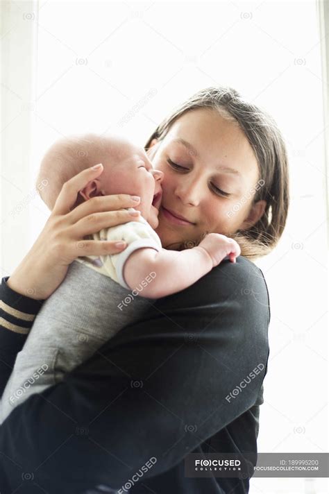 Teenage girl holding little baby sister crying — children, kids - Stock ...