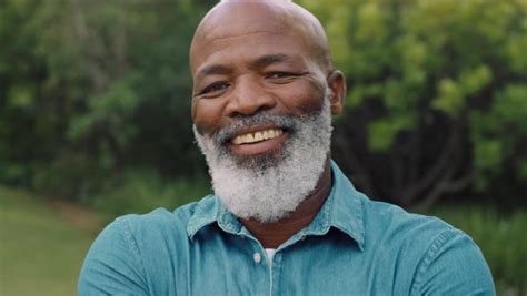 Portrait old african american man smiling looking happy in park enjoying successful retirement ...