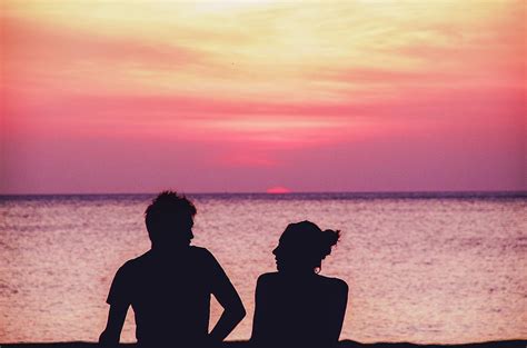 Silhouette of a couple sitting on the beach and talking during the sunset Photograph by Srdjan ...