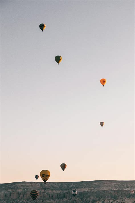 Hot air balloons flying in sky over highlands in daytime · Free Stock Photo