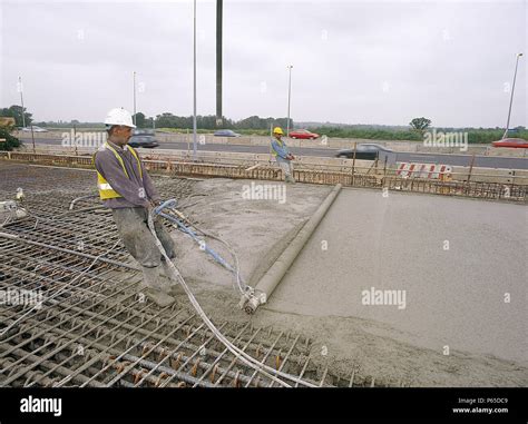 Manually screeding reinforced in situ concrete road slab. United Kingdom Stock Photo - Alamy