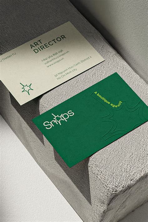 a green business card sitting on top of a concrete block