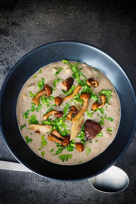 Over head portrait image of a bowl of cream of mushroom soup in a black ...