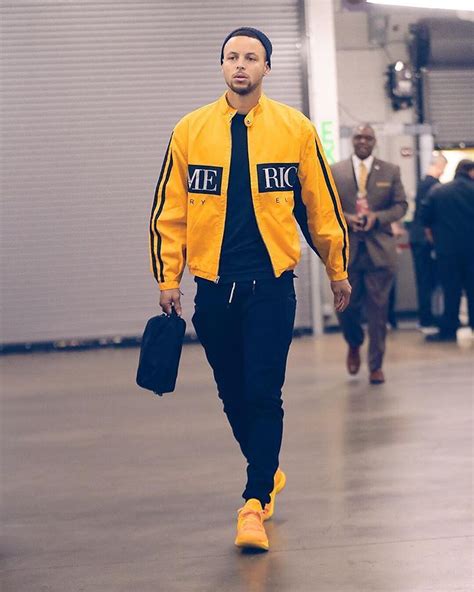 a man in a yellow jacket and black tie walking down a hall with other ...