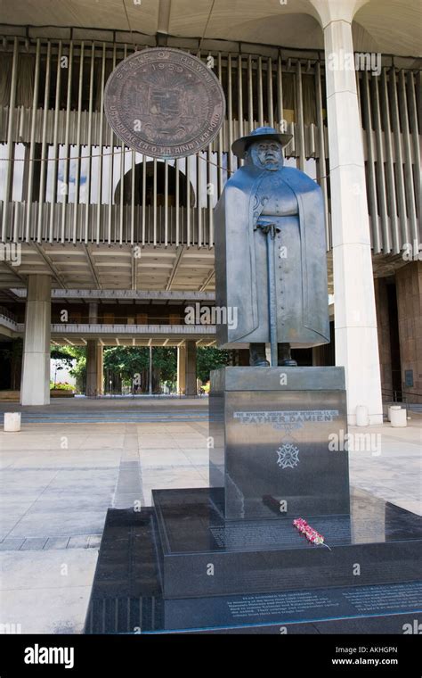 Statue of Father Damien in front of the Hawaii statehouse with bronze state seal or pendant in ...