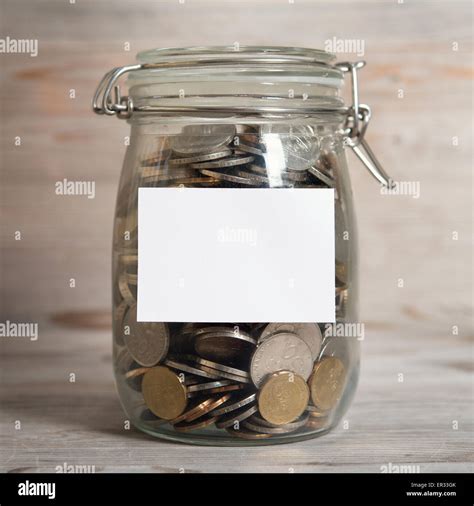 Coins in glass money jar with white blank label, financial concept ...