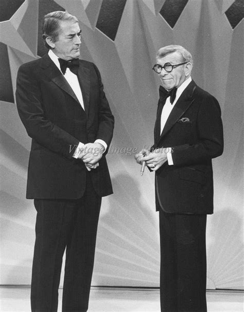 two men in tuxedos are standing next to each other on a stage with an ...