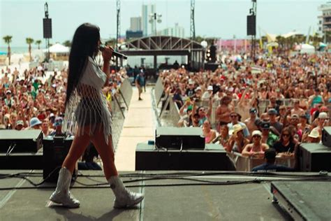 a woman standing on top of a stage in front of a large group of people