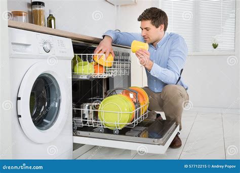 Man Arranging Dishes in Dishwasher Stock Image - Image of happy, crouching: 57712215