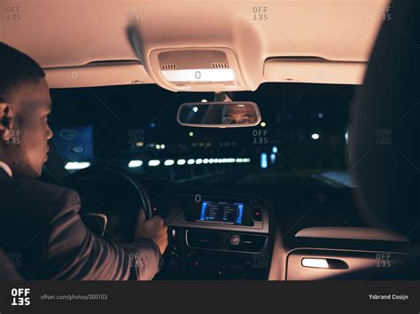 Stylish man inside a car at night stock photo - OFFSET