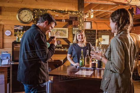 Caucasian people drinking wine in winery - Stock Photo - Dissolve