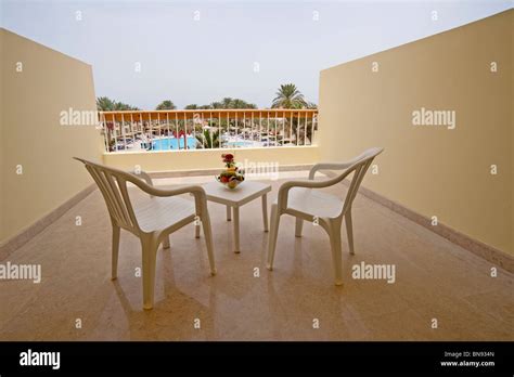 View of a swimming pool from a hotel balcony with chairs and table ...