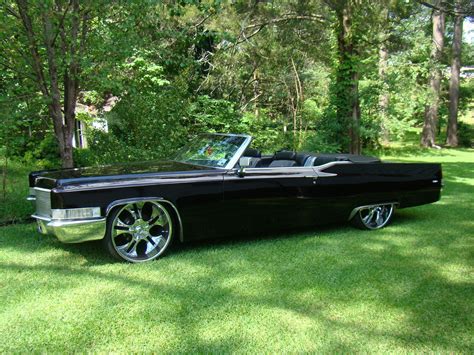 an old black convertible car parked in the grass