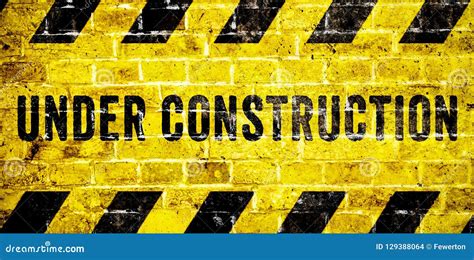 Under Construction Warning Sign with Yellow and Black Stripes on Brick ...