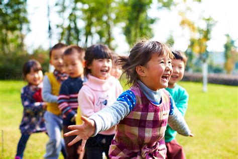 "Happy Asian Kids Playing Outdoor In The Park" by Stocksy Contributor "Bo Bo" - Stocksy