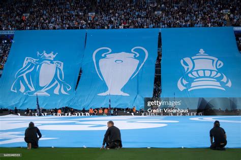 Manchester City fans unvweil a banner with the three trophies from ...