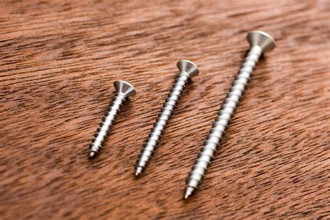 Free Image of Three screws lying on wooden | Freebie.Photography