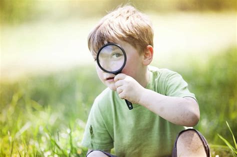 Portrait of boy looking through magnifying glass stock photo