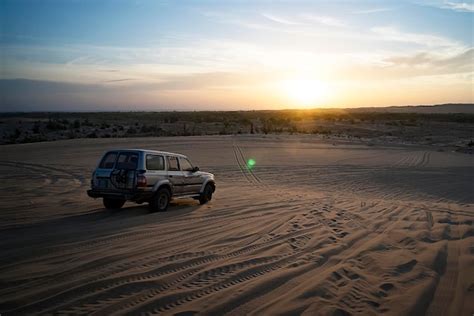 Premium Photo | Colorful sunset in Desert offroad car rides on the sand in the desert dunes in ...