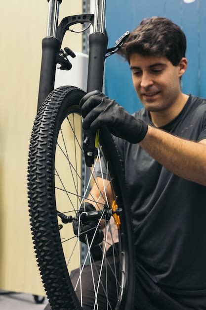 Premium Photo | Mechanic removing bicycle wheel in workshop