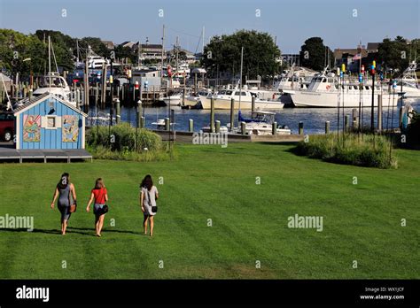 The view of Hyannis harbor with three young females walking towards it ...