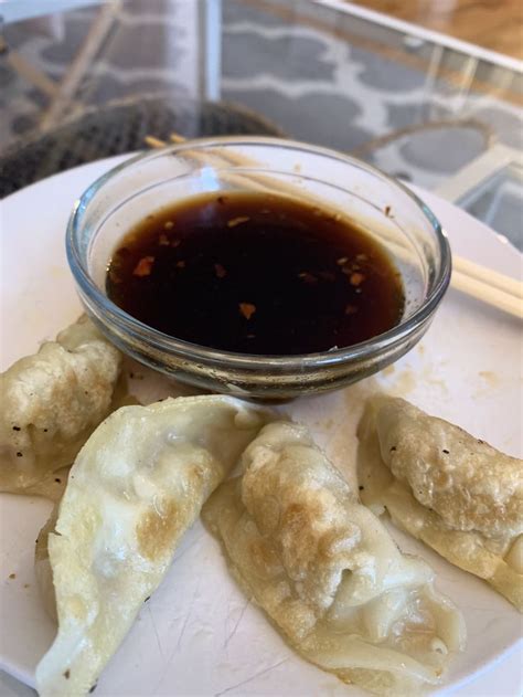 some dumplings on a plate with dipping sauce