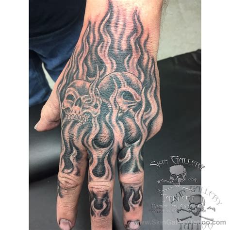 brentseverson:hand-tattoo-flames-fire-skulls-cover-up-black-and-gray