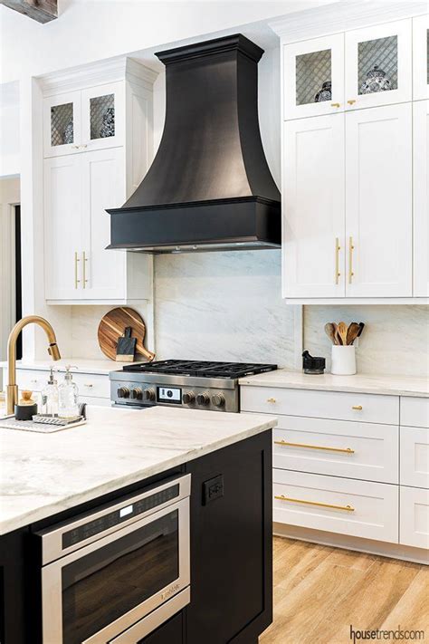 A beautiful black range hood picks up the tone of the nearby island. #housetrends | Kitchen hood ...