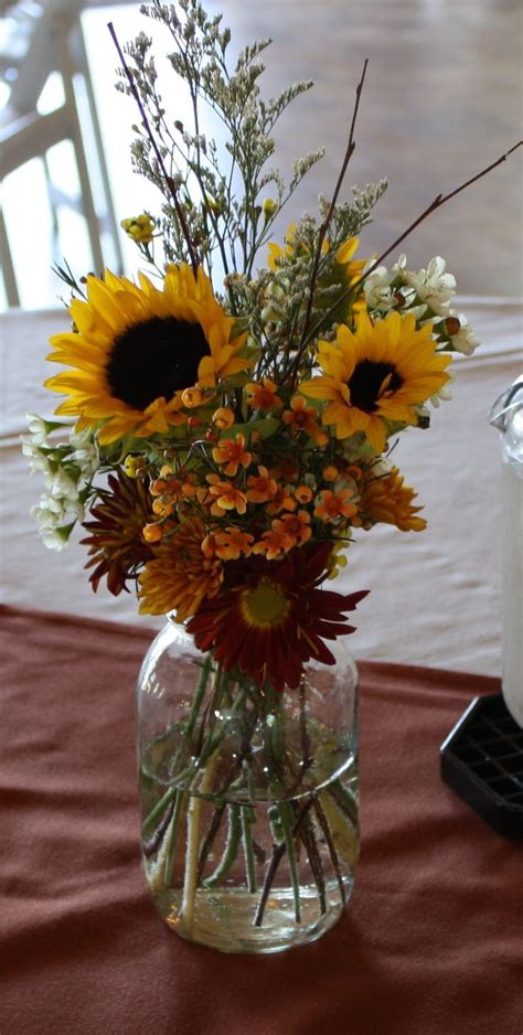 Simple autumn mason jar centerpiece with sunflowers at a fall party. Maneeley's Lodge in South ...