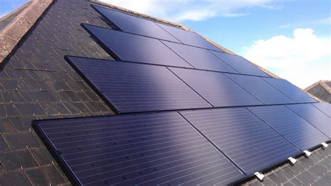 three solar panels on the roof of a building with blue skies in the ...