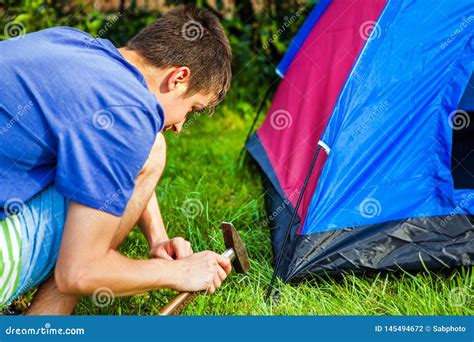 Man setting up a tent stock photo. Image of tourist - 145494672