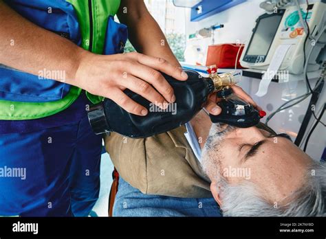 Emergency doctor doing artificial ventilation of lungs and CPR to ...