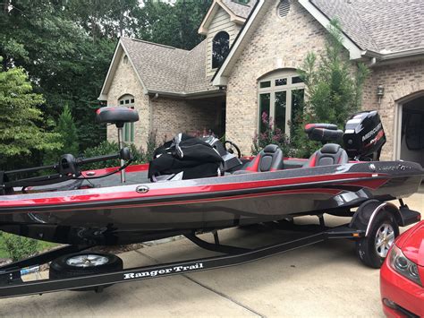 a red and black boat parked in front of a house