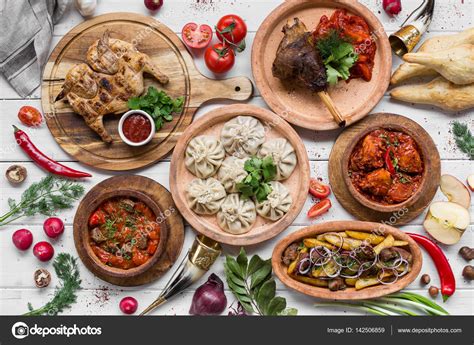 A lot of food on the wooden table. Georgian cuisine. Top view. Flat lay . Khinkali and Georgian ...