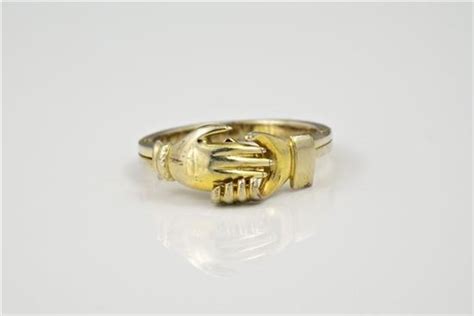 Lot - A 9ct yellow gold and enamel gimmel and fedé ring the hinged shank opening to reveal a red ...