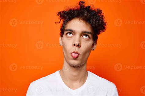 man in white t-shirt curly hair orange background 21985777 Stock Photo ...