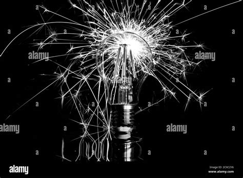 Fireworks sparkler behind LED light bulb - black white Stock Photo - Alamy