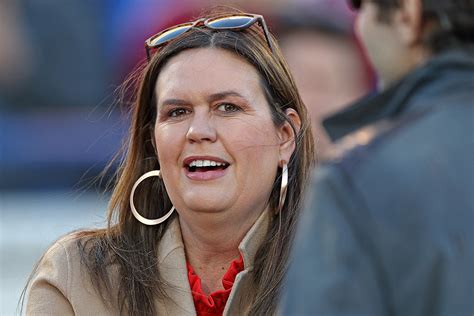 Sarah Huckabee Sanders Pops in Fiery-Red Top for Razorbacks Football – Footwear News