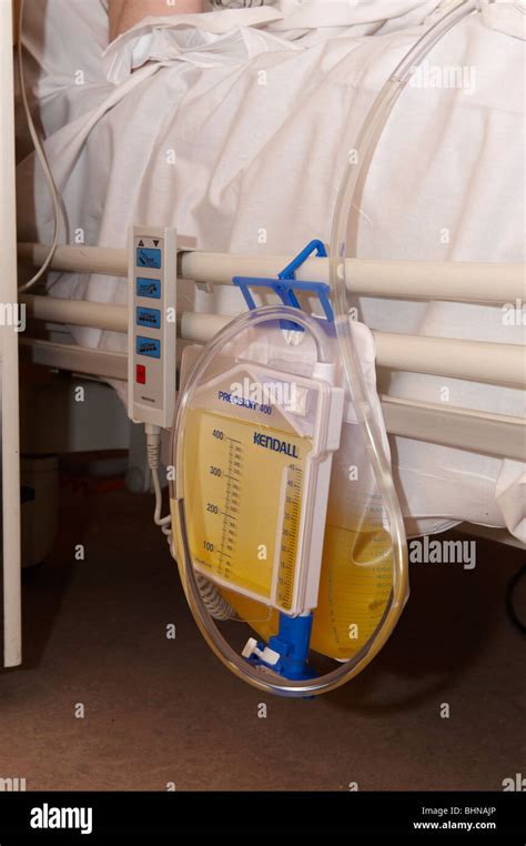 Hospital catheter urine bag strapped to side of bed Stock Photo - Alamy