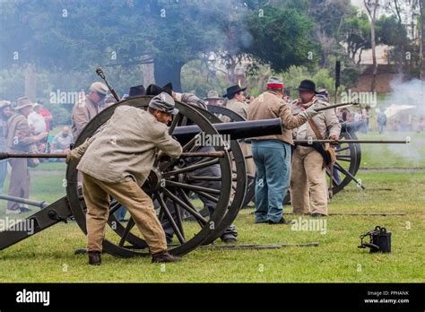 confederate soldiers firing a cannon during a battle at a American Civil war reenactment in ...