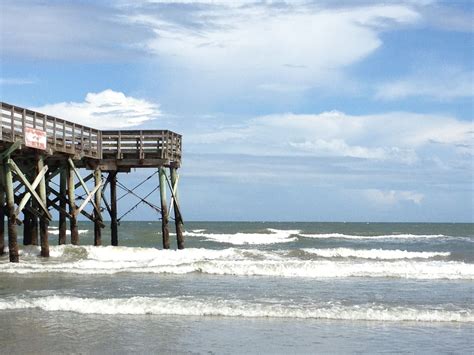 a pier on the beach with waves coming in