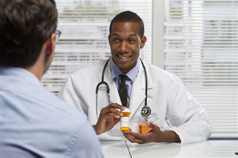 22665451 – young black doctor showing patient prescription, horizontal – African Union Expo