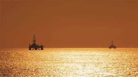 Two offshore oil rigs during sunset - Consumer Energy Alliance