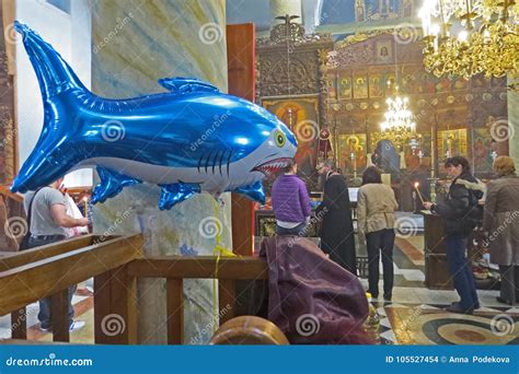 Inflatable Shark in the Orthodox Church. Balloon for Children with Helium Amongst Praying People ...